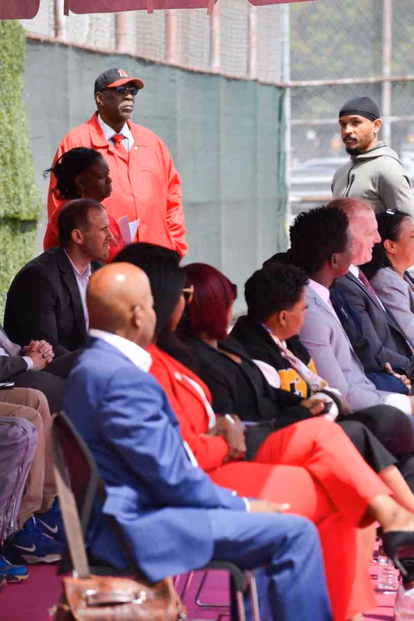 Guests and officials seated at an outdoor school ceremony event