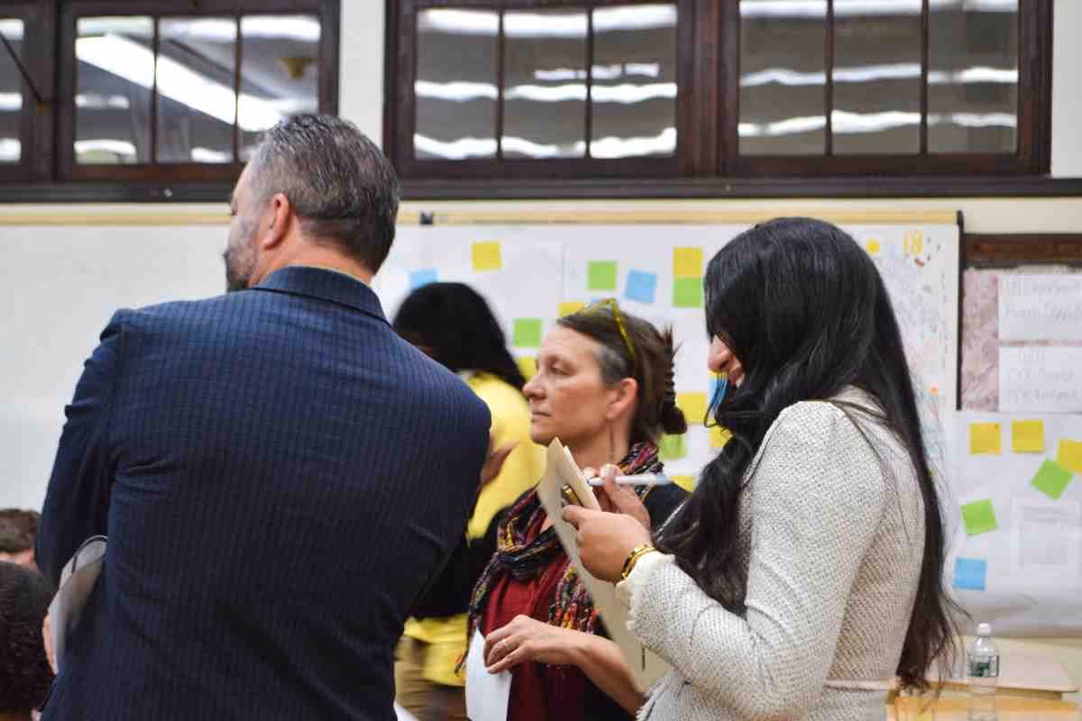Adults collaborating at a school workshop with sticky note boards