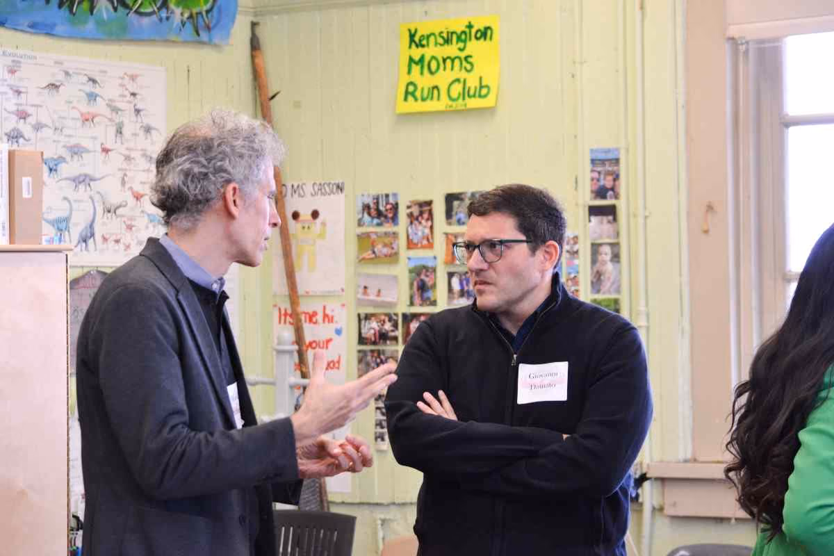Two adults with name tags in conversation at a school community event