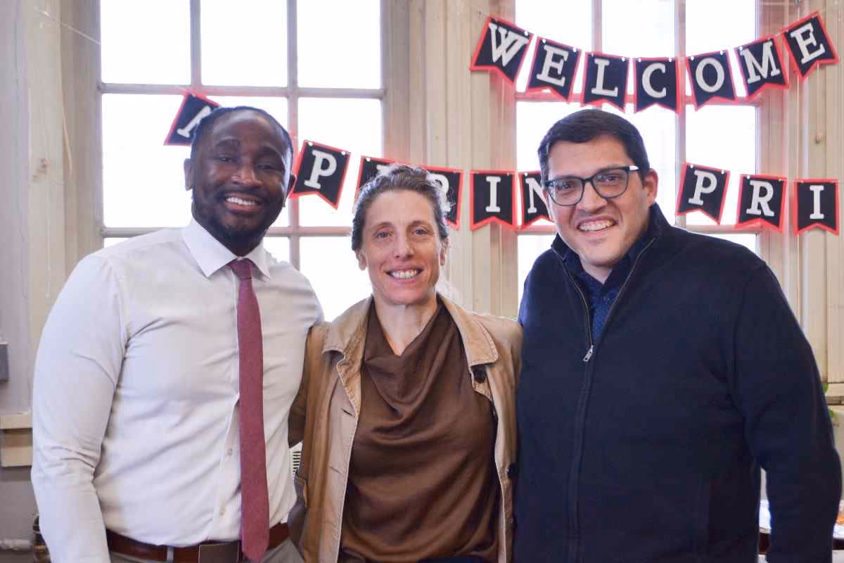 Three staff members smiling at welcome aspiring principals school event