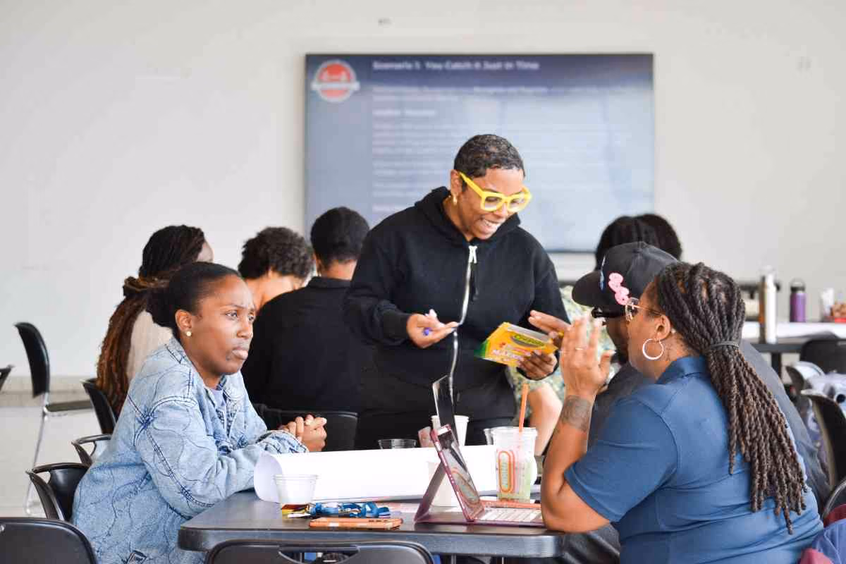Instructor with yellow glasses leading small group discussion at workshop