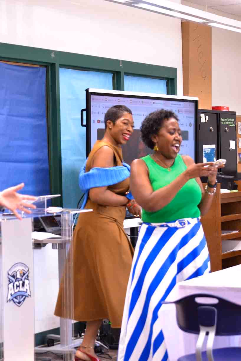 Two women laughing together during a school leadership presentation event