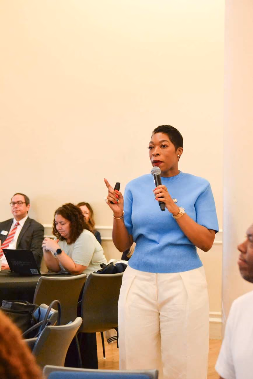 Woman speaking into microphone at a school community meeting