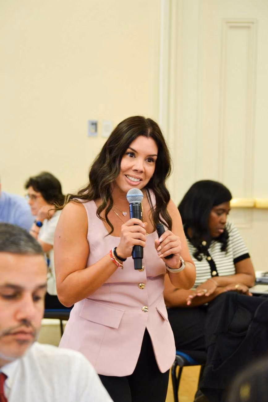 Woman speaking into microphone at a school meeting or conference