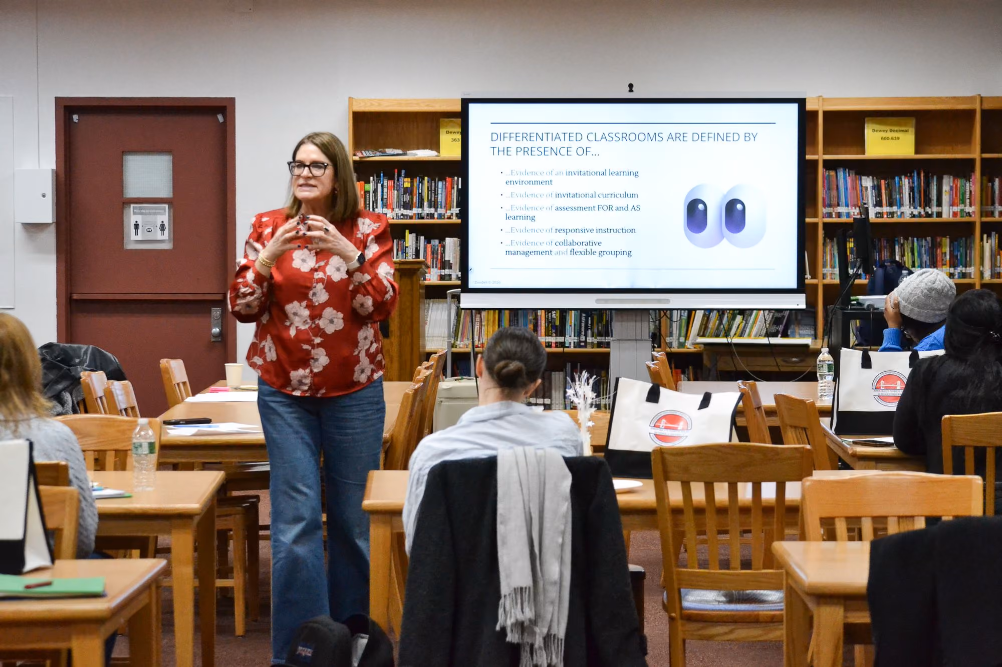 Teacher presenting differentiated classroom strategies to staff in school library