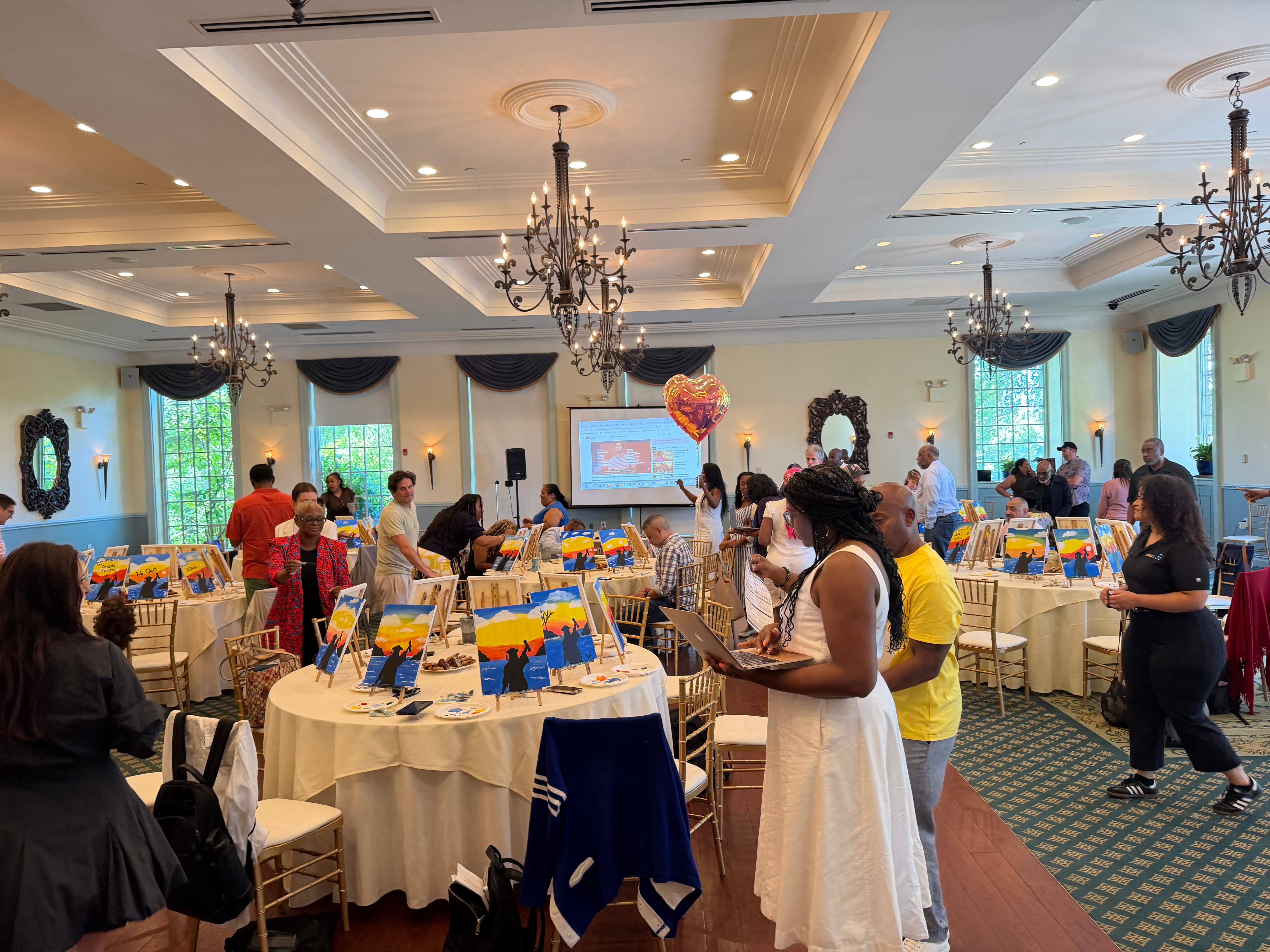 Attendees mingle at a school community paint and sip event