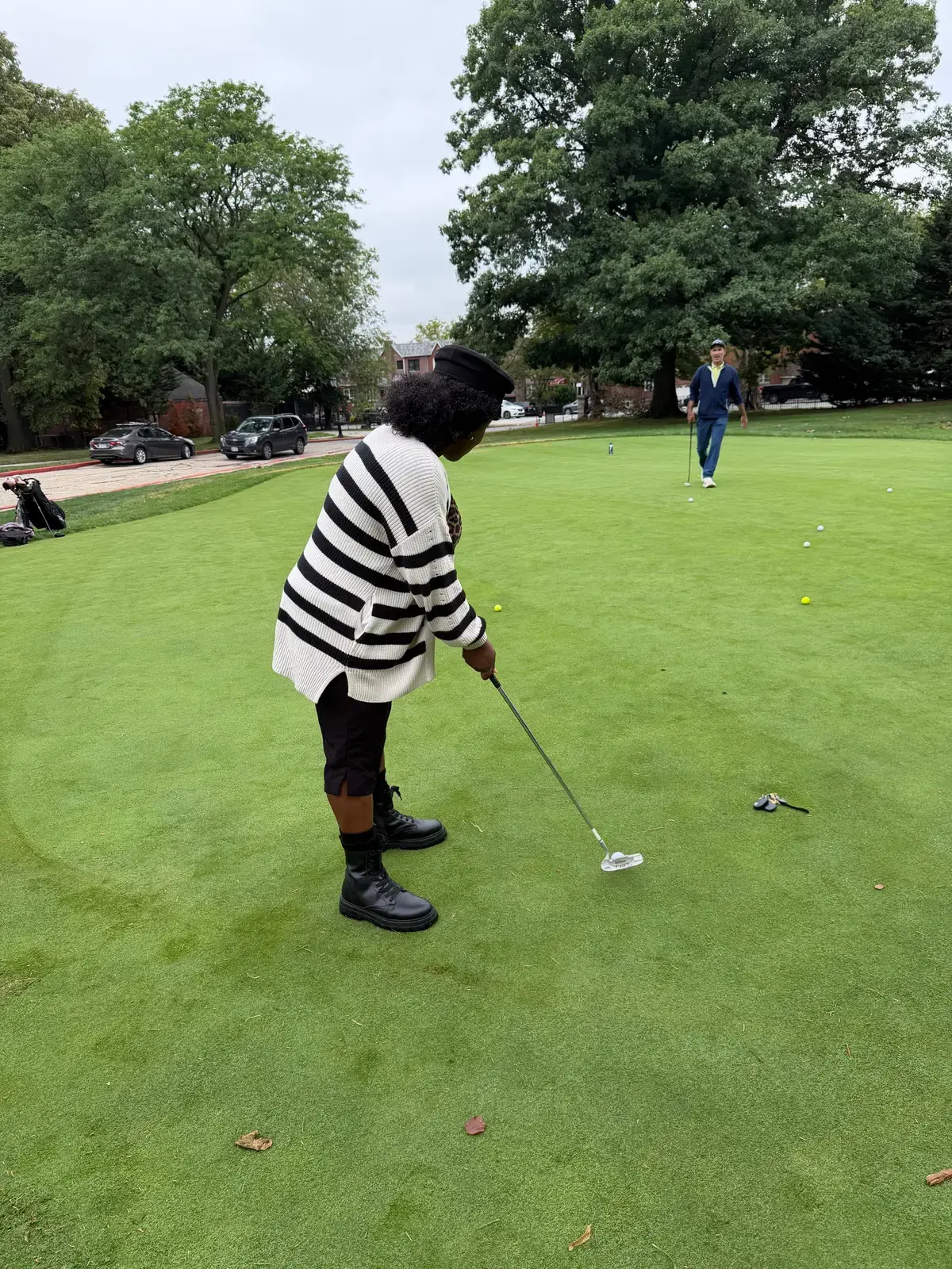 Student putting on a golf green during outdoor golf activity