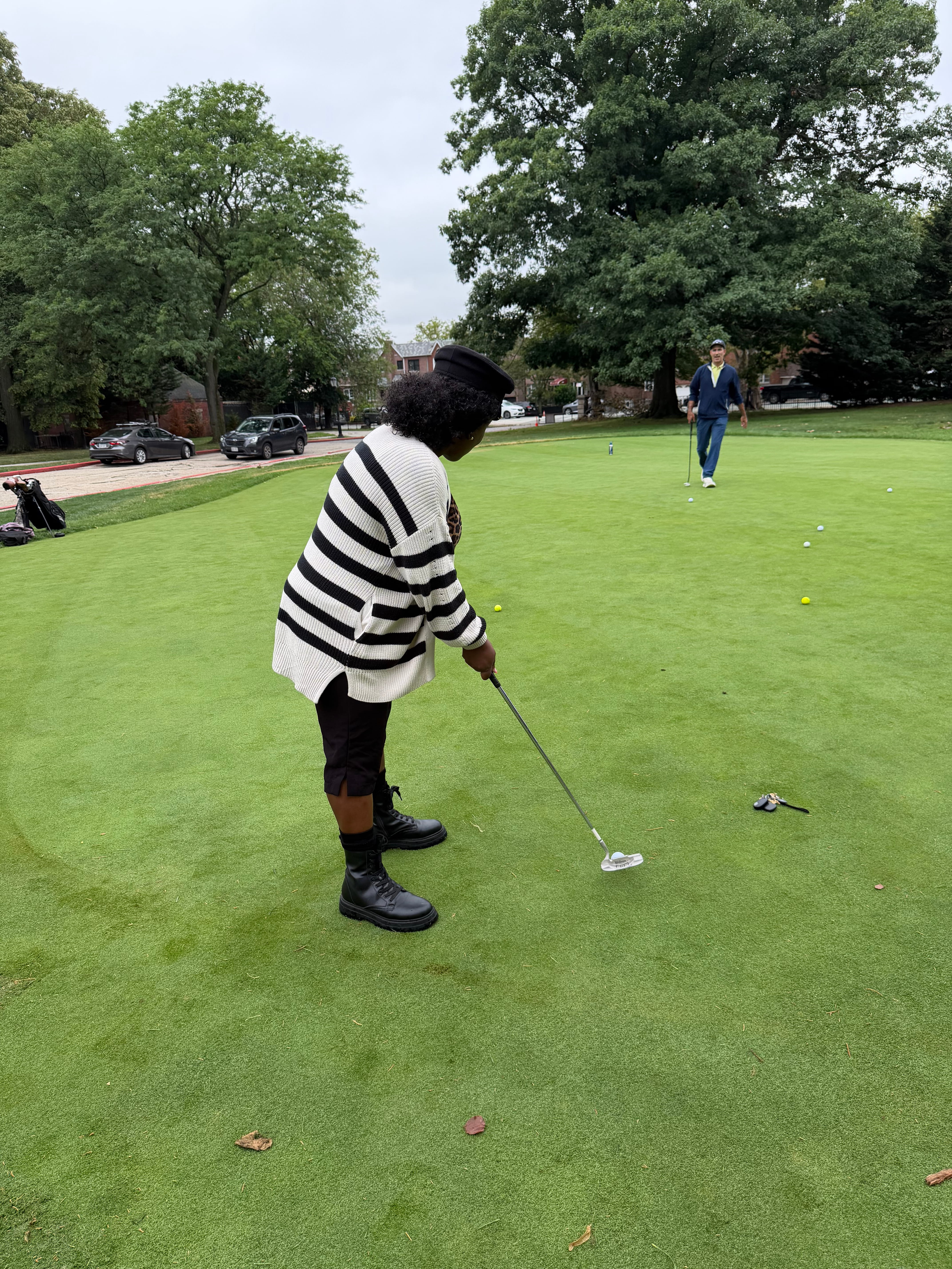 Student putting on a golf green during outdoor golf activity