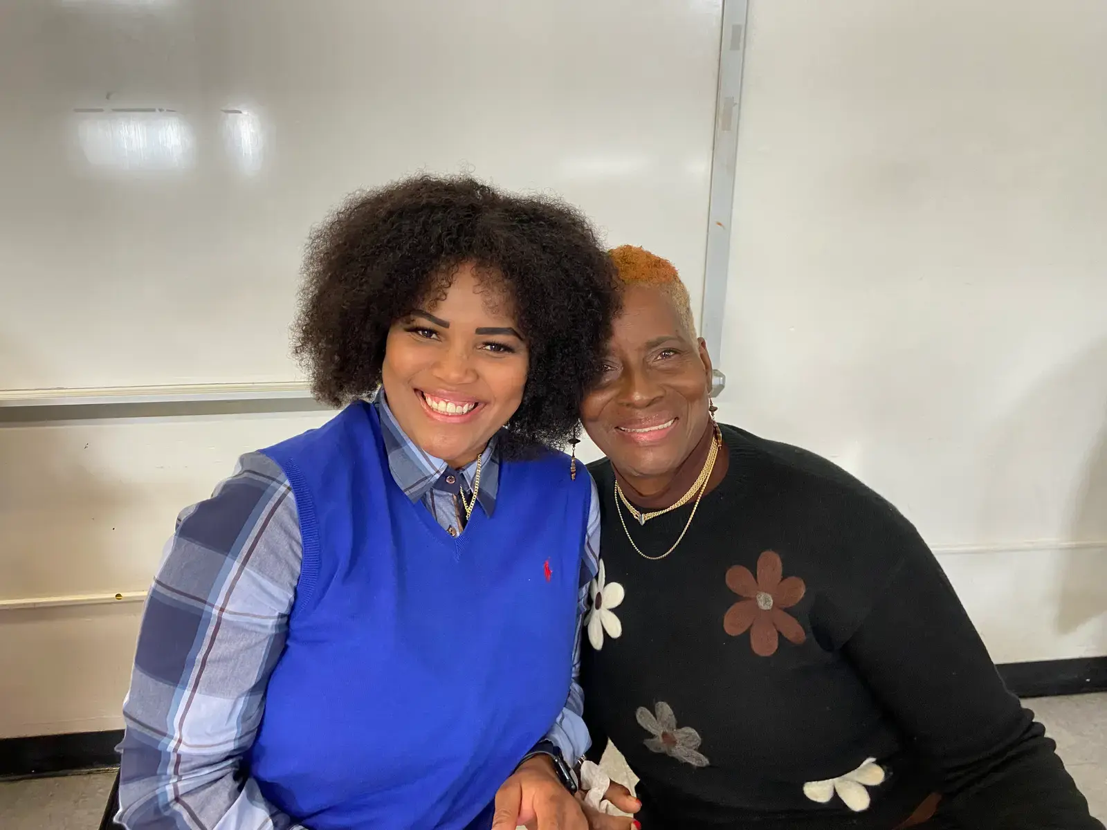 Two women smiling together in a classroom setting