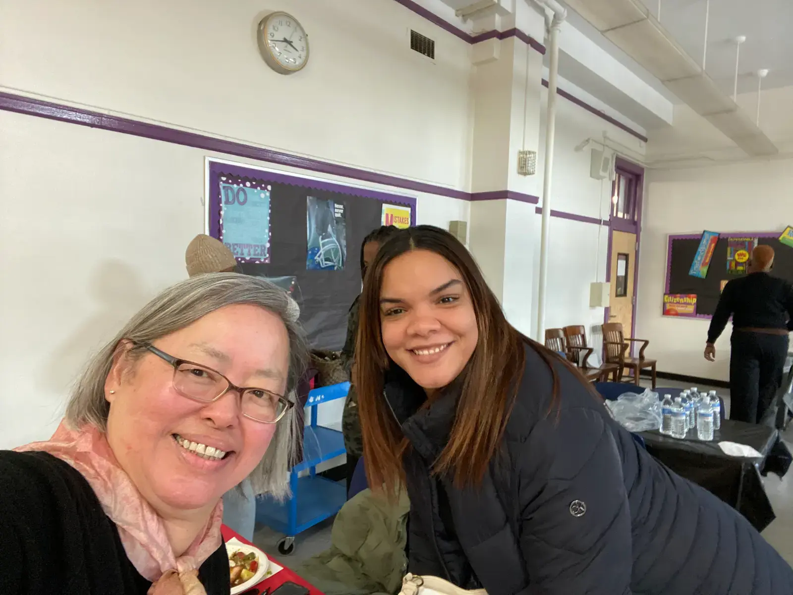 Two women smiling together at a school community event