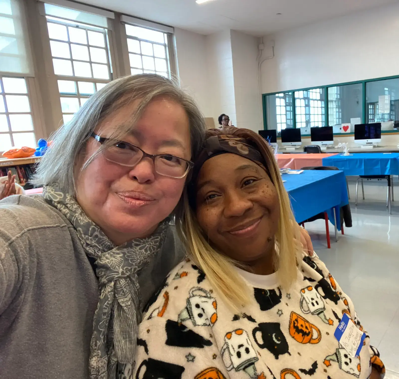 Two smiling women posing together at a school community event