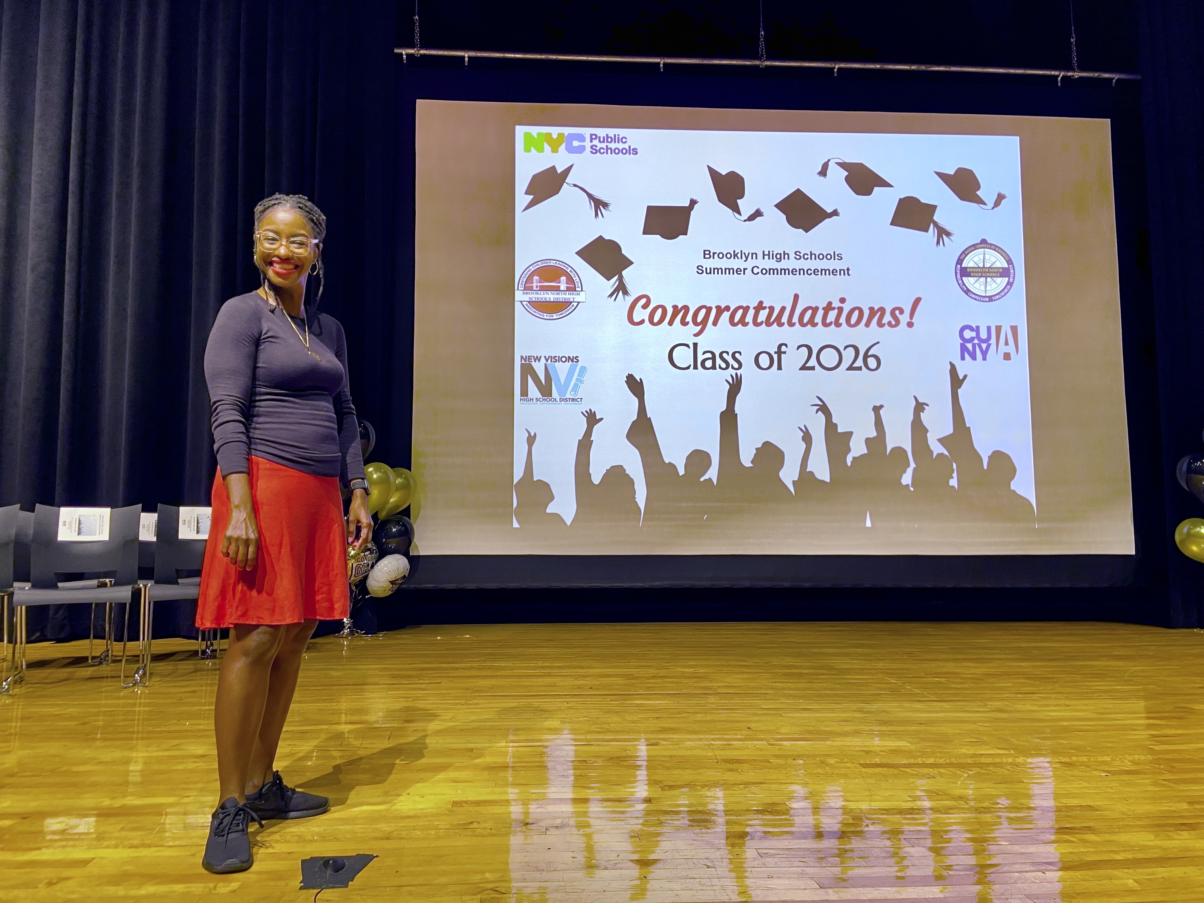 Staff member poses at Brooklyn High Schools Class of 2026 Summer Commencement ceremony