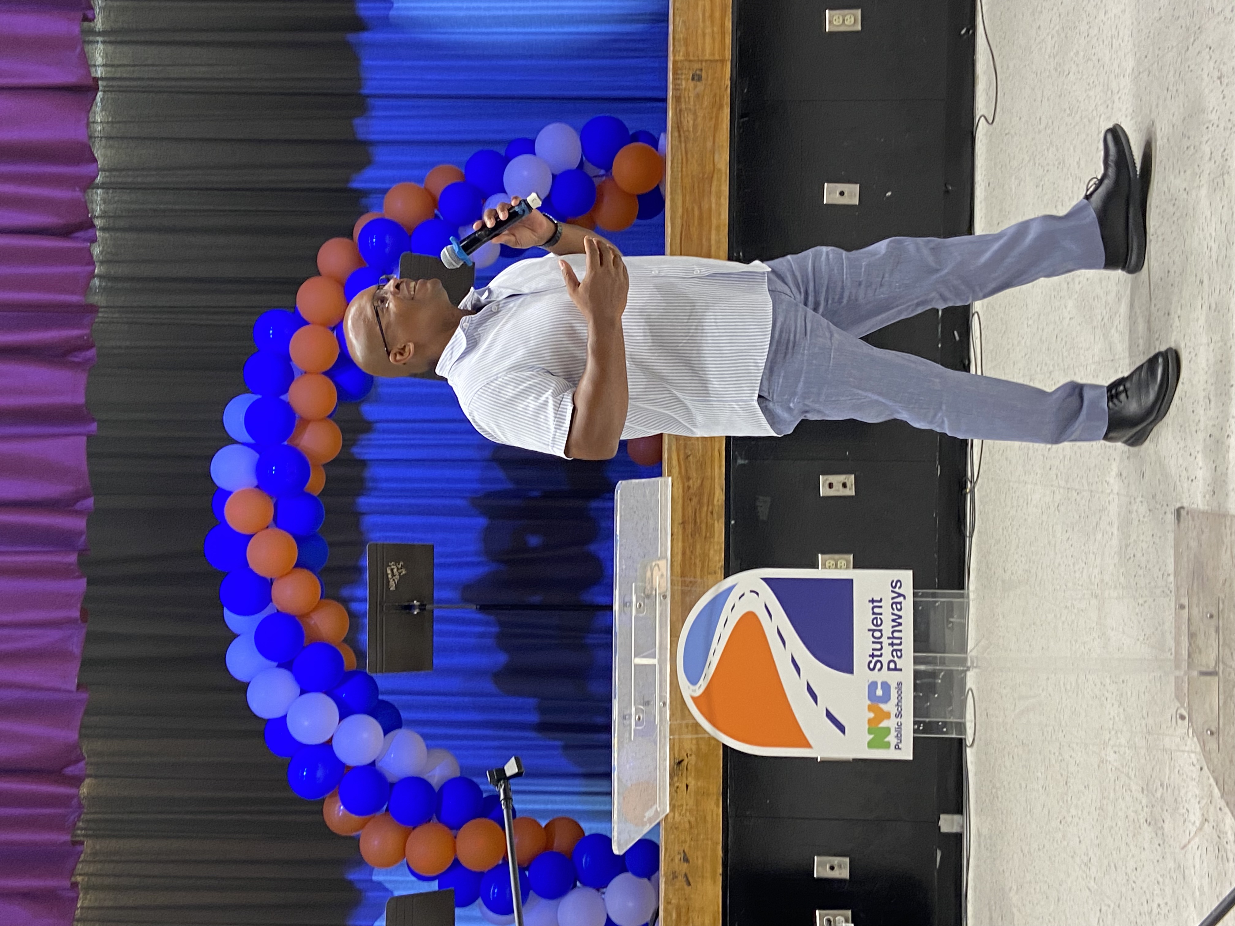 Speaker addresses audience at NYC Student Pathways event with balloons