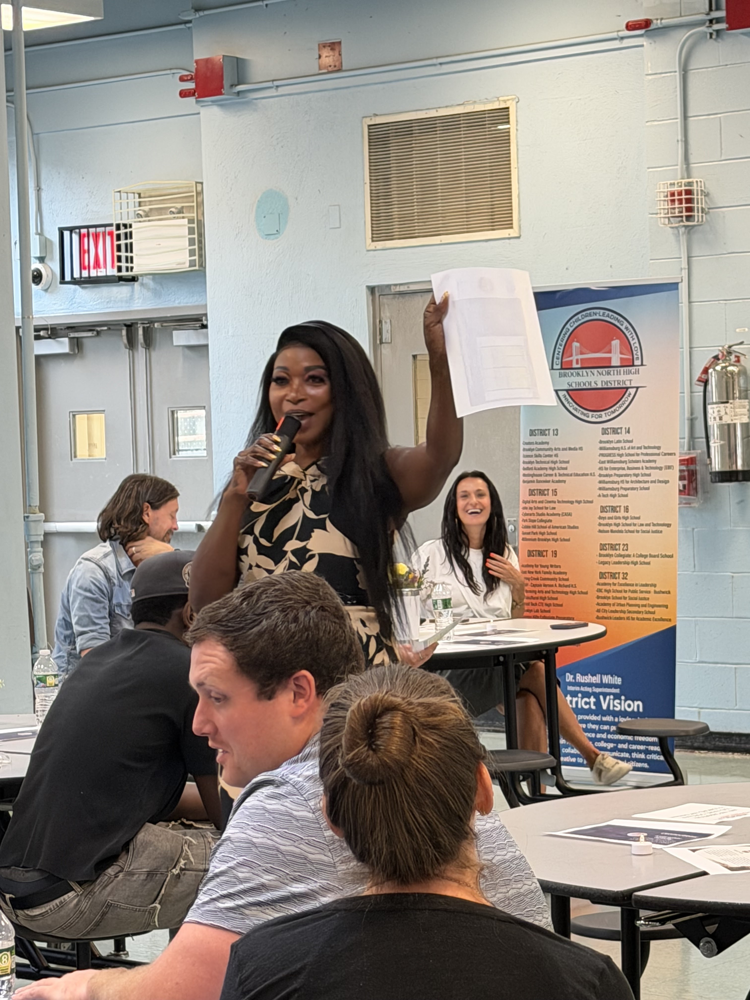 Presenter holding document and speaking at Brooklyn North High Schools District event