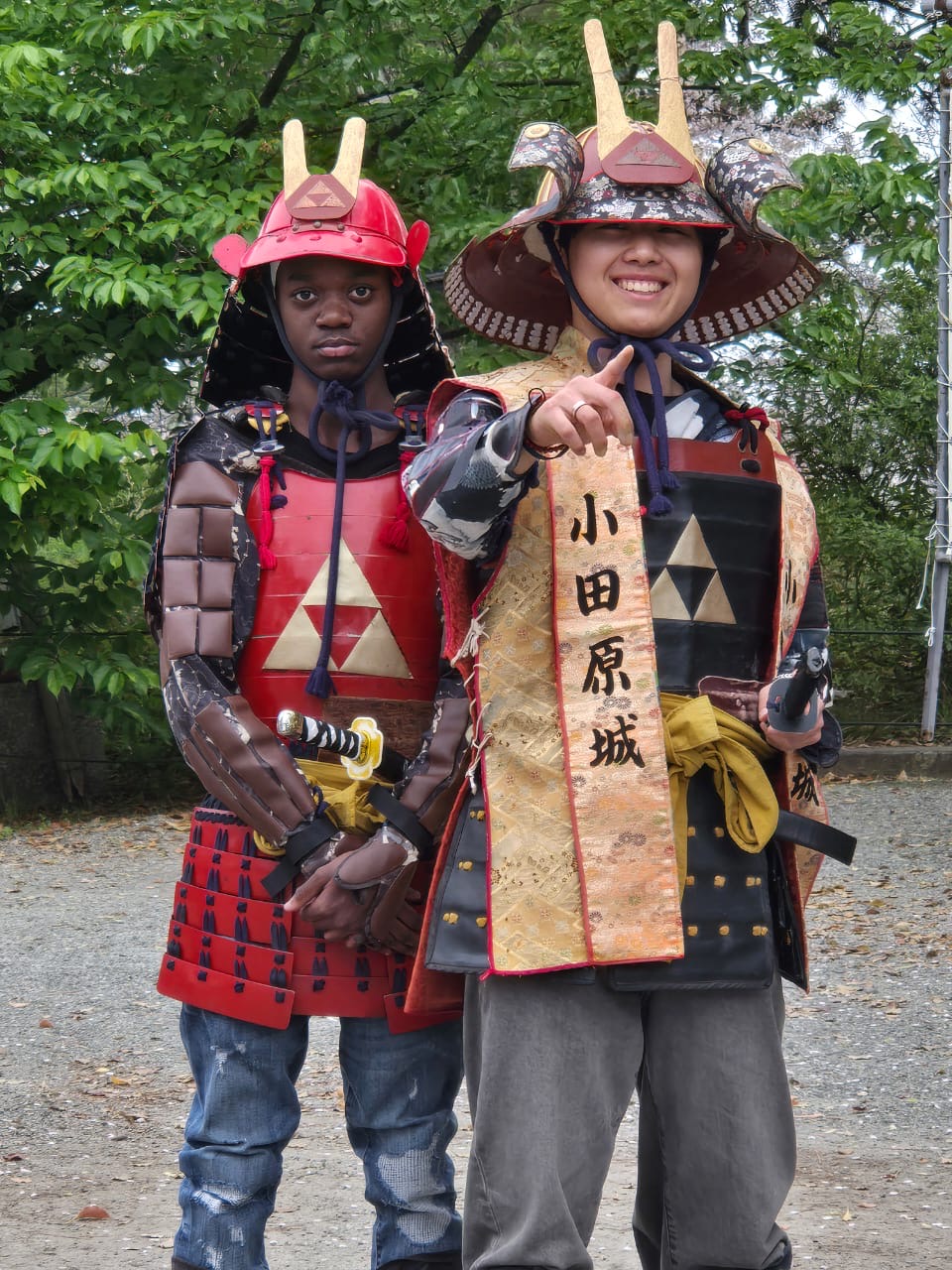 Two students wearing traditional Japanese samurai armor costumes outdoors