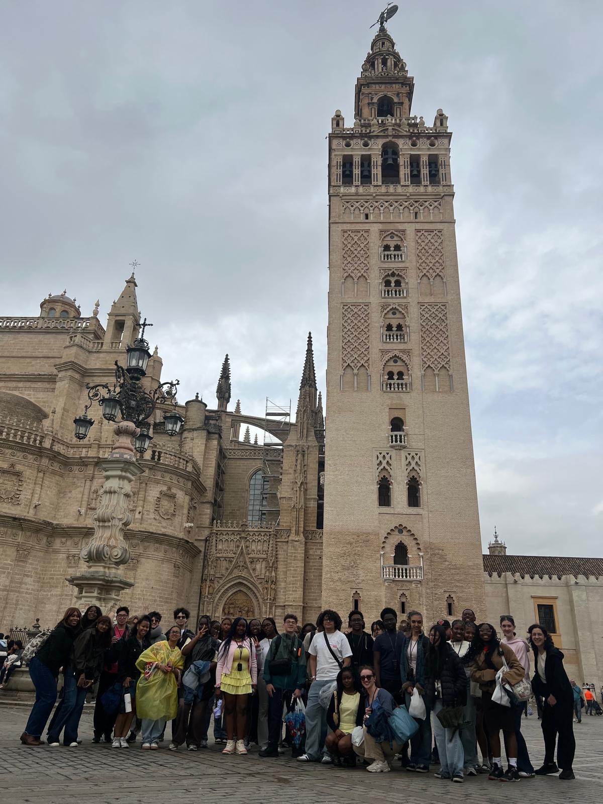 Students posing in front of Seville Cathedral and Giralda tower Spain