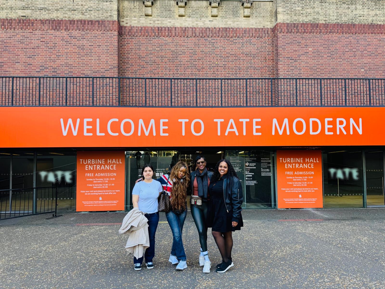 Students posing outside Tate Modern art gallery entrance in London