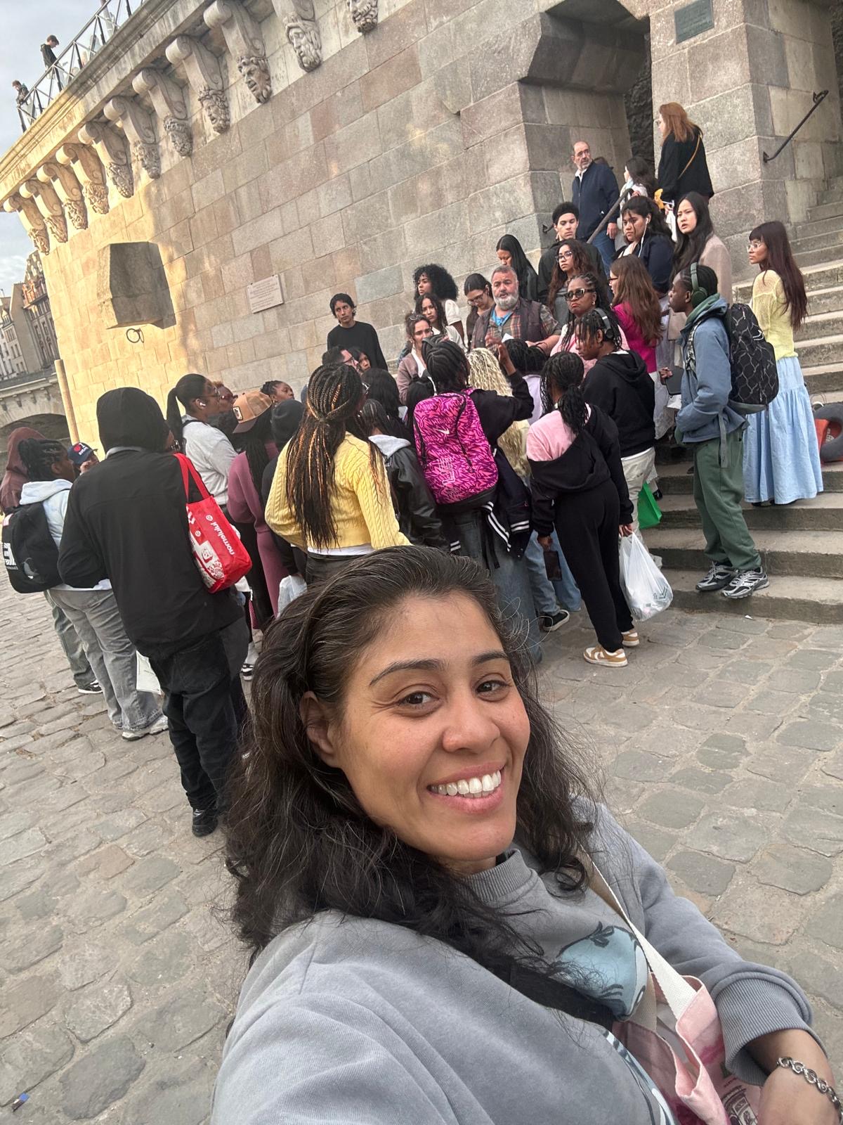 Teacher selfie with student group on historic building steps abroad