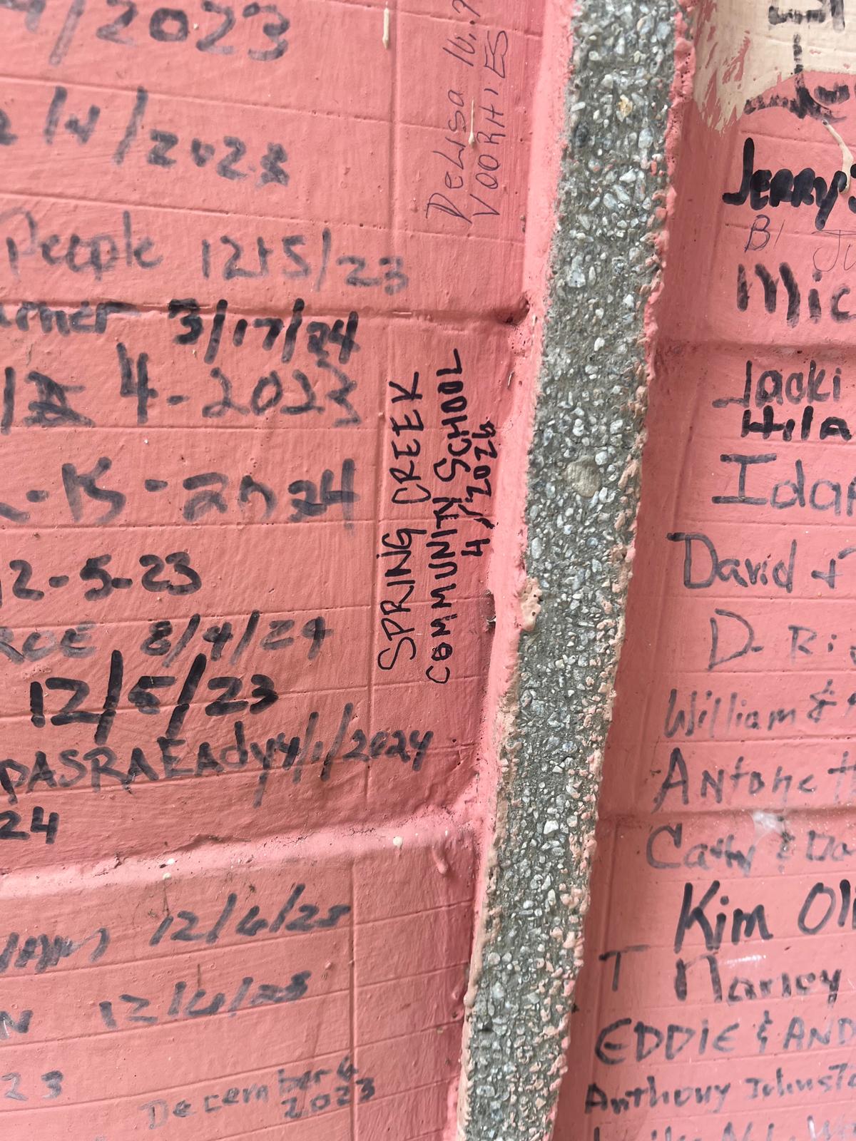 Spring Creek Community School name signed on brick wall with dates