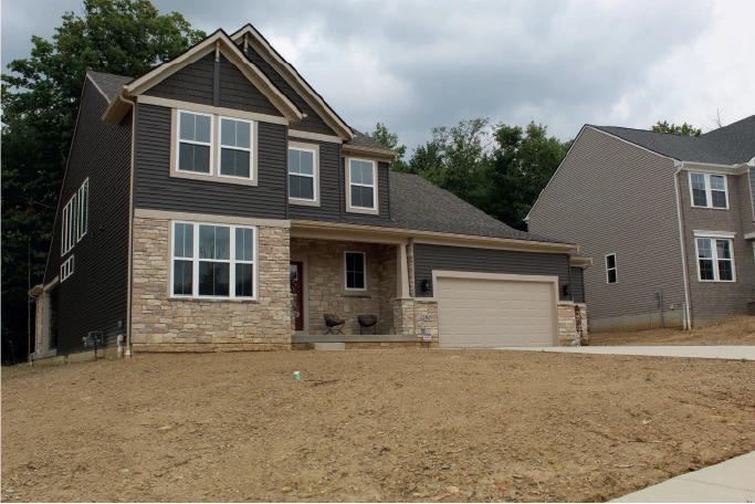 newly built home with tan stone siding