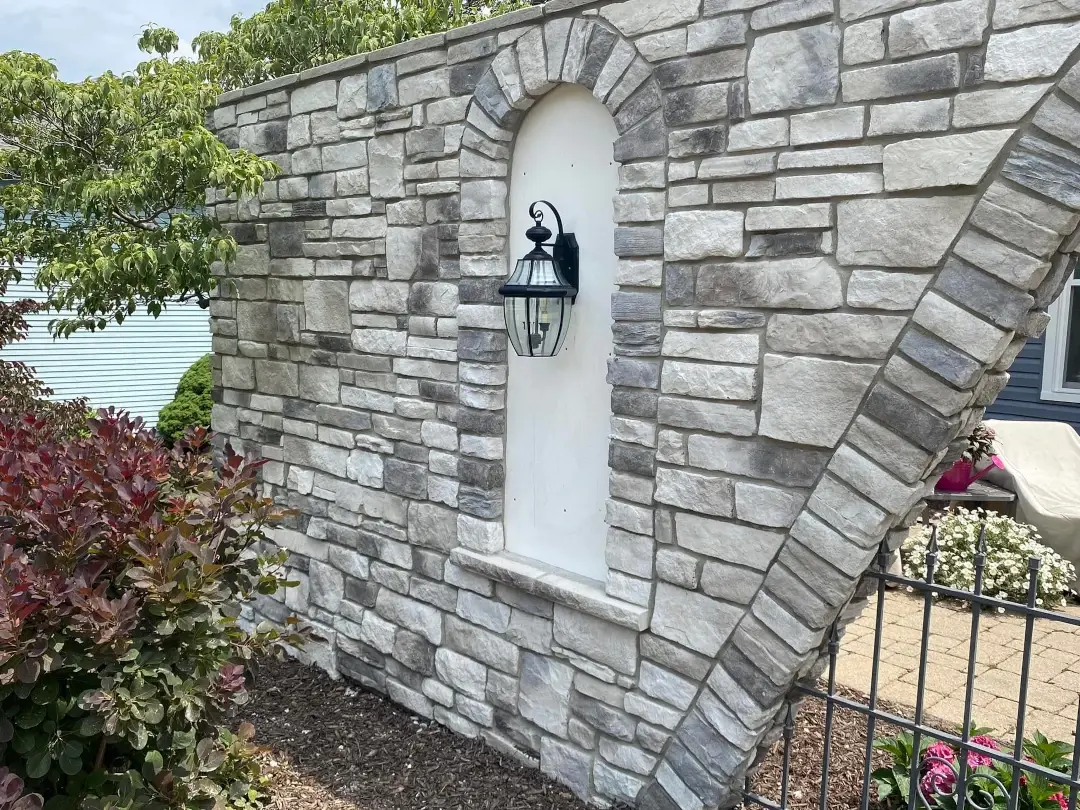 handing light fixture on side of stone arch wall