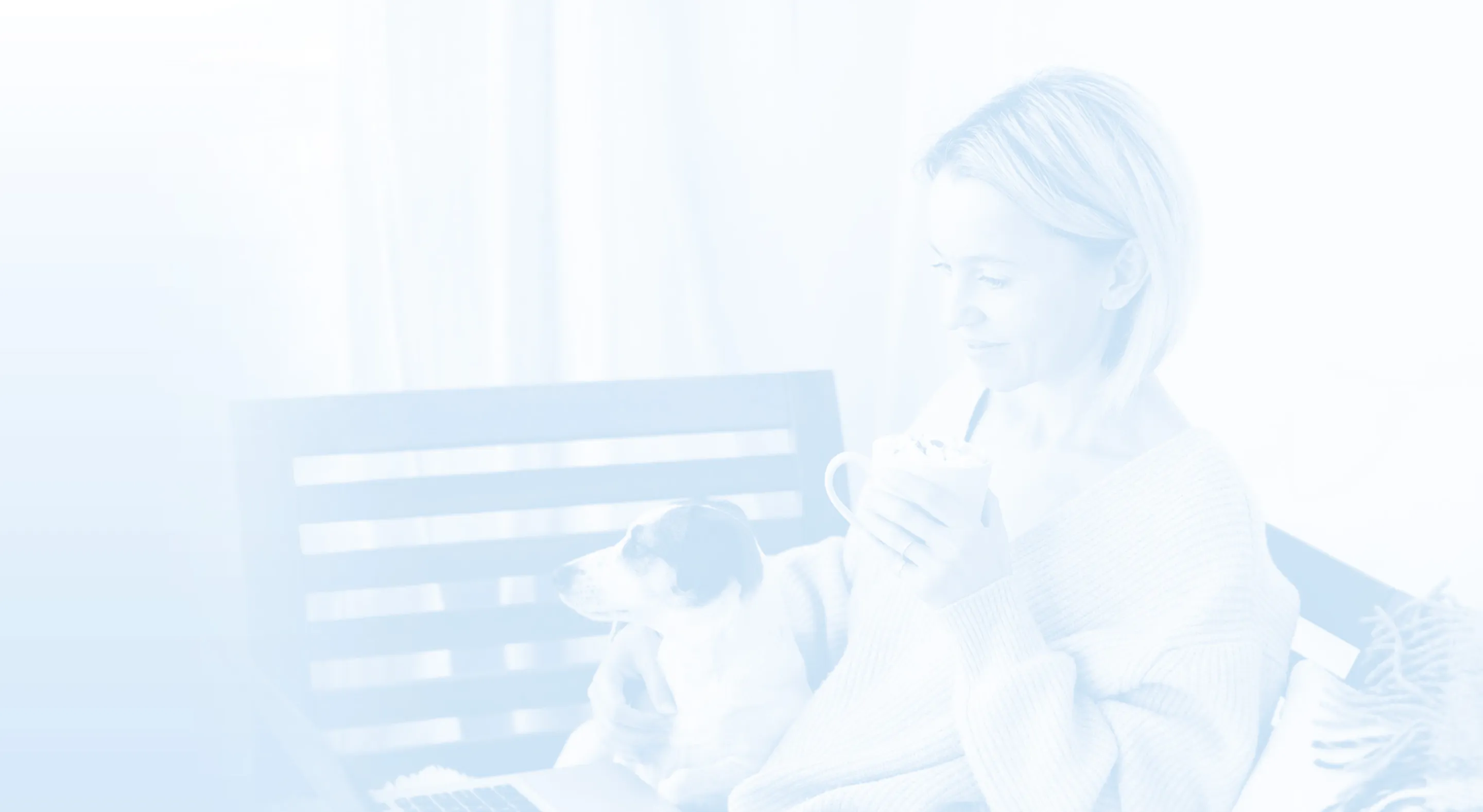 Woman sitting on a bench holding a mug and petting a small dog on her lap with a laptop nearby.