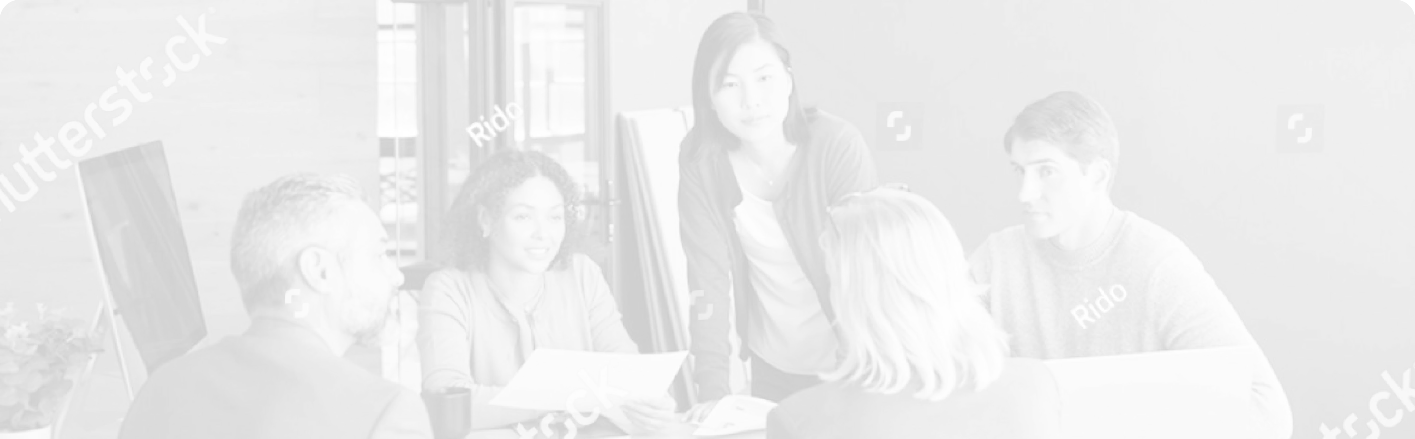 Two focused people working on laptops in a modern office space.