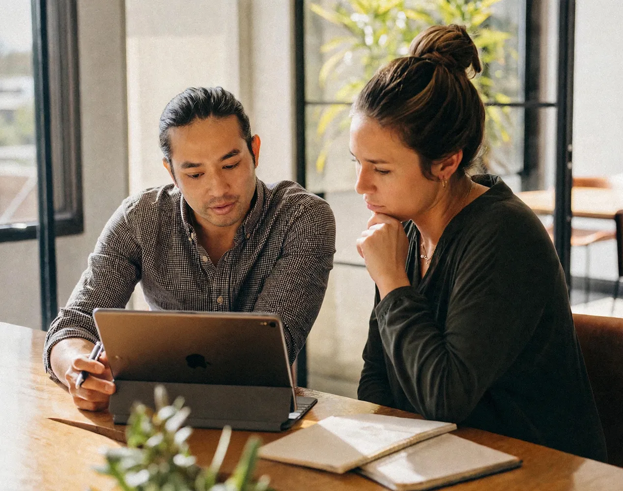 Two colleagues reviewing information together on a laptop at a table.