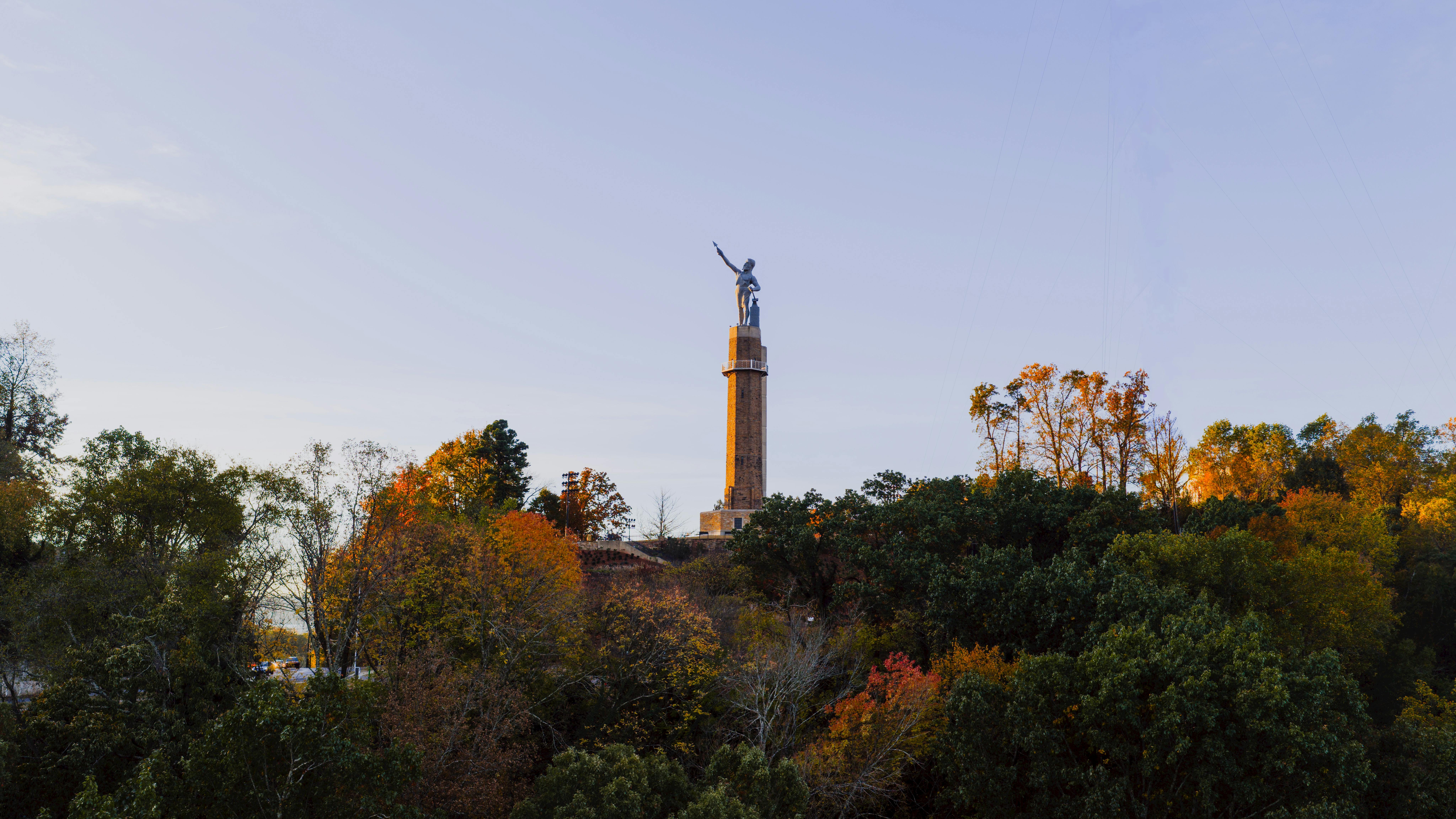 The Vulcan Statue bathed in sunset light and surrounded by trees