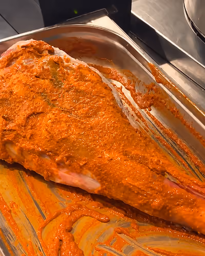 Whole leg of lamb marinated in yogurt and spices before slow roasting