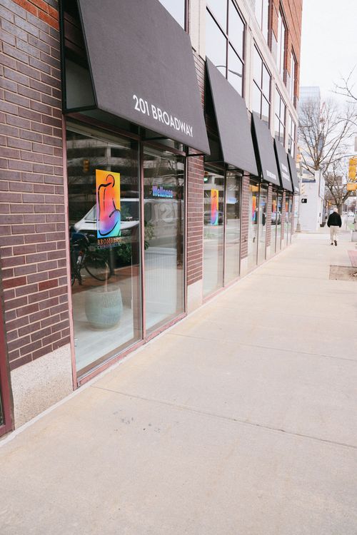 Building storefront with black awnings displaying 201 BROADWAY and Bromberg Chiropractic logo on windows.