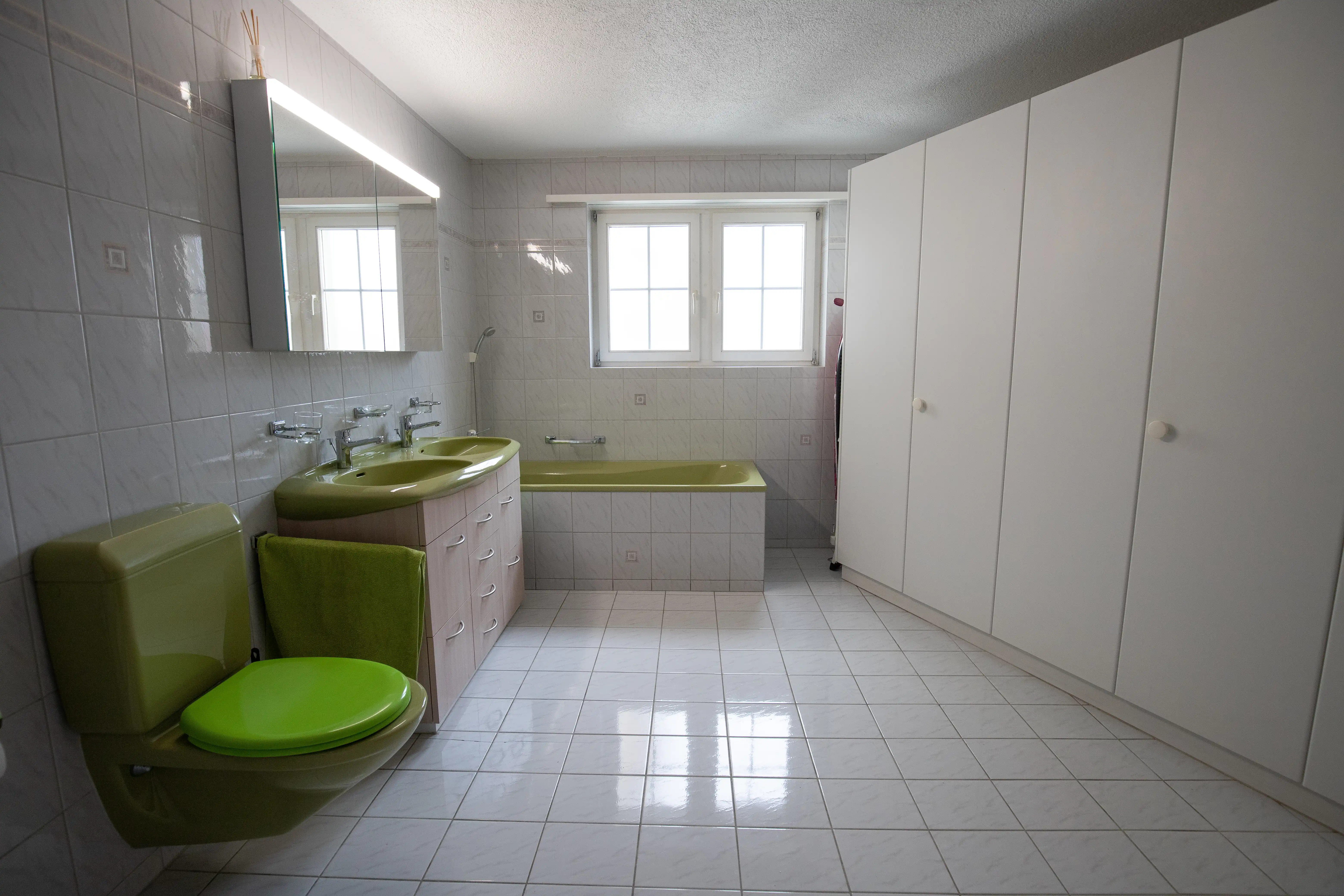 Grosses helles Badezimmer mit Badewanne, Doppelwaschbecken und separatem WC