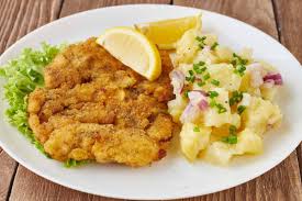 Knusprig gebackenes Wiener Schnitzel mit Zitrone und Kartoffelsalat im Restaurant Hirschen Heuringen