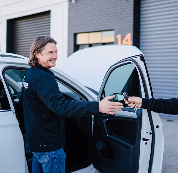 Customer completing car sale by handing over keys.