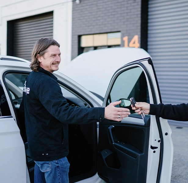 Customer completing car sale by handing over keys.
