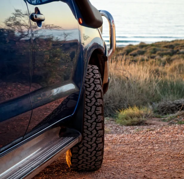 Used 4WD vehicle parked near coastal track in New Zealand.
