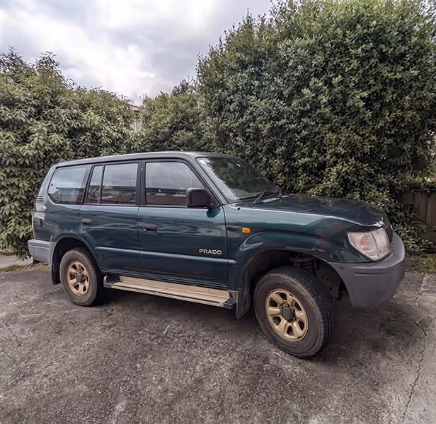 Older SUV parked in driveway ready for car removal.