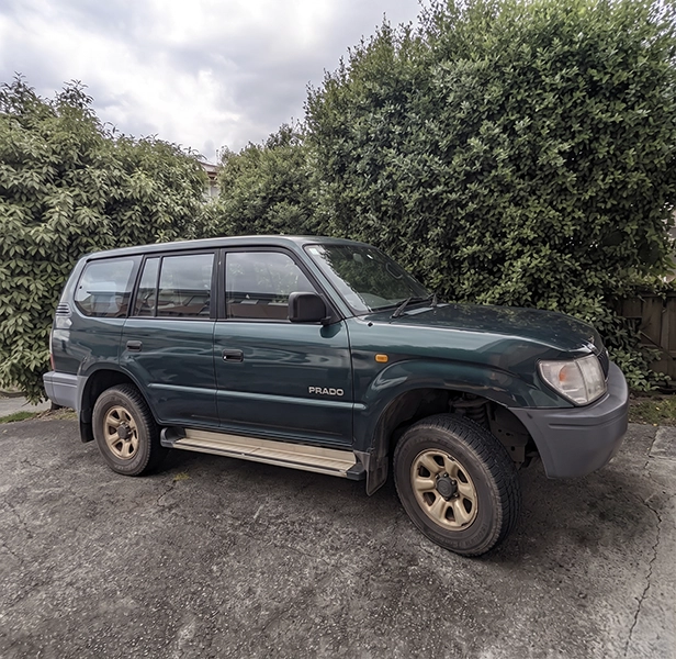 Older SUV parked in driveway ready for car removal.