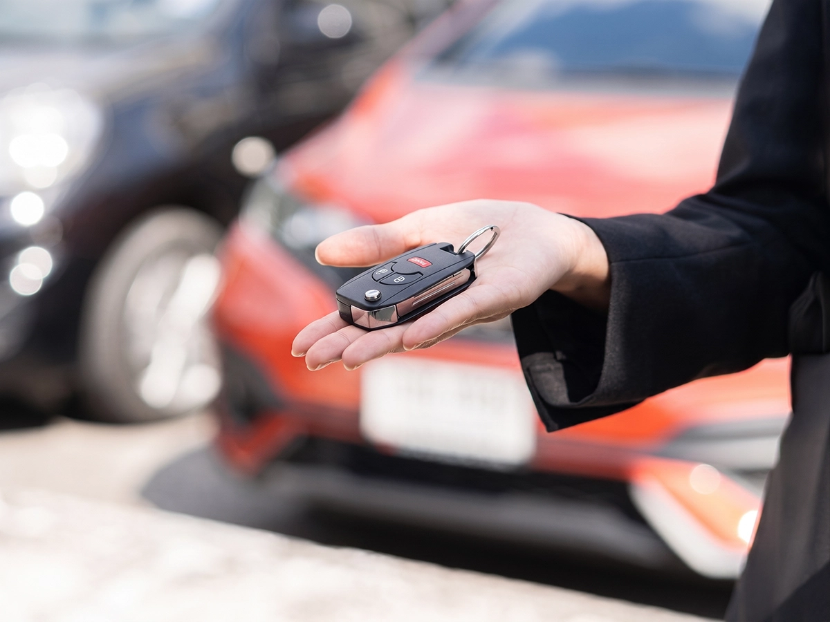 Close-up of car keys being handed over, showing the process of selling a vehicle.