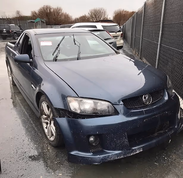 Silver sedan with severe front-end crash damage, showing a crumpled bonnet, smashed bumper, and exposed engine components.