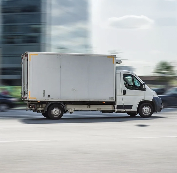 Used box truck driving on the road ready for sale or removal.
