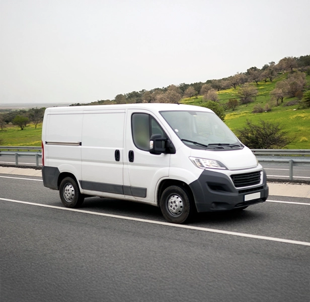 White work van on the road, similar to vans we buy for cash across New Zealand.