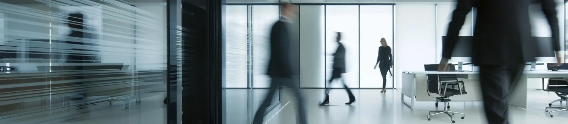 Modern clothing store interior with shelves and racks of neatly arranged garments and blurred shoppers walking.