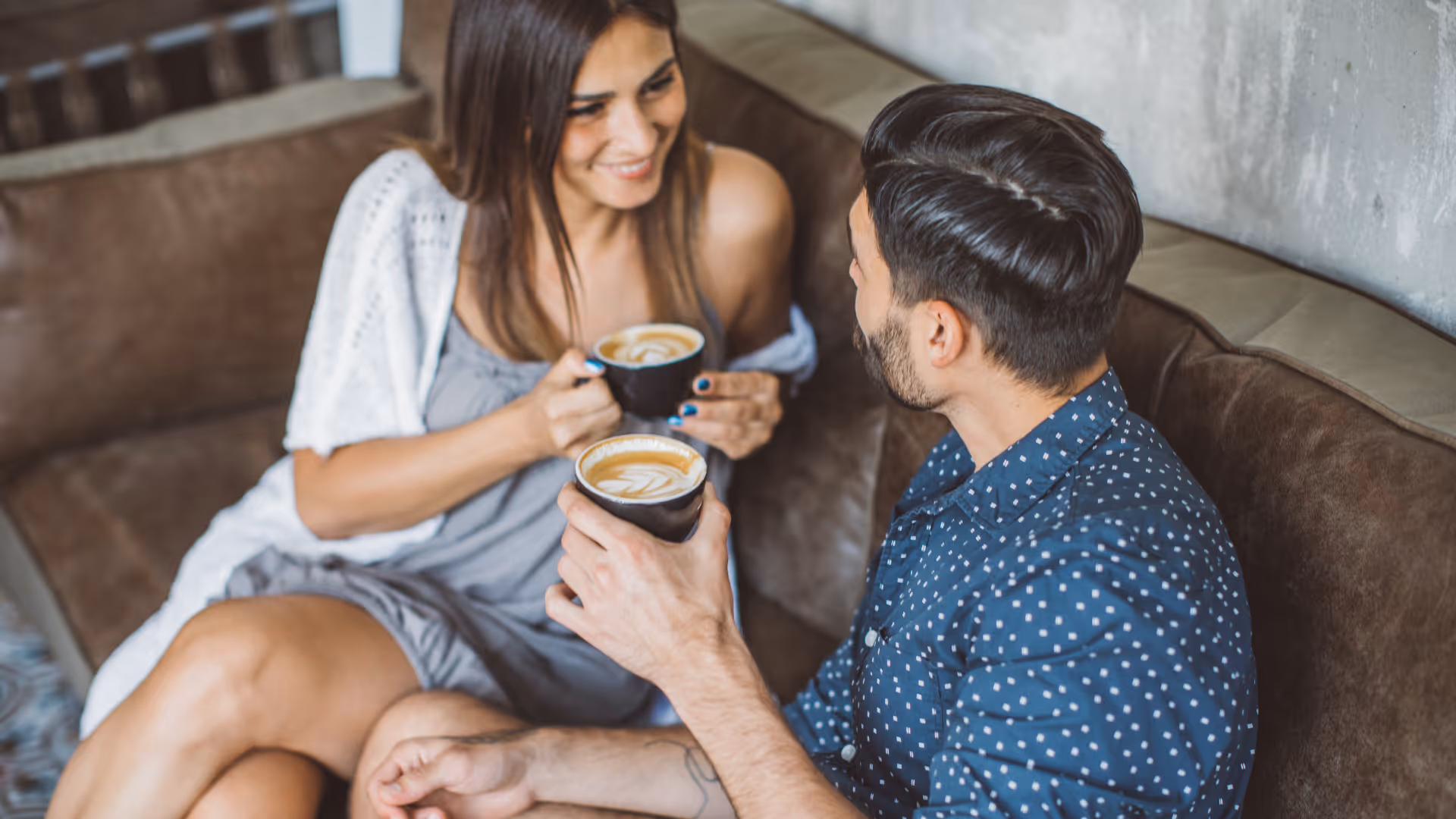 Couple drinking lattes on couch stock image
