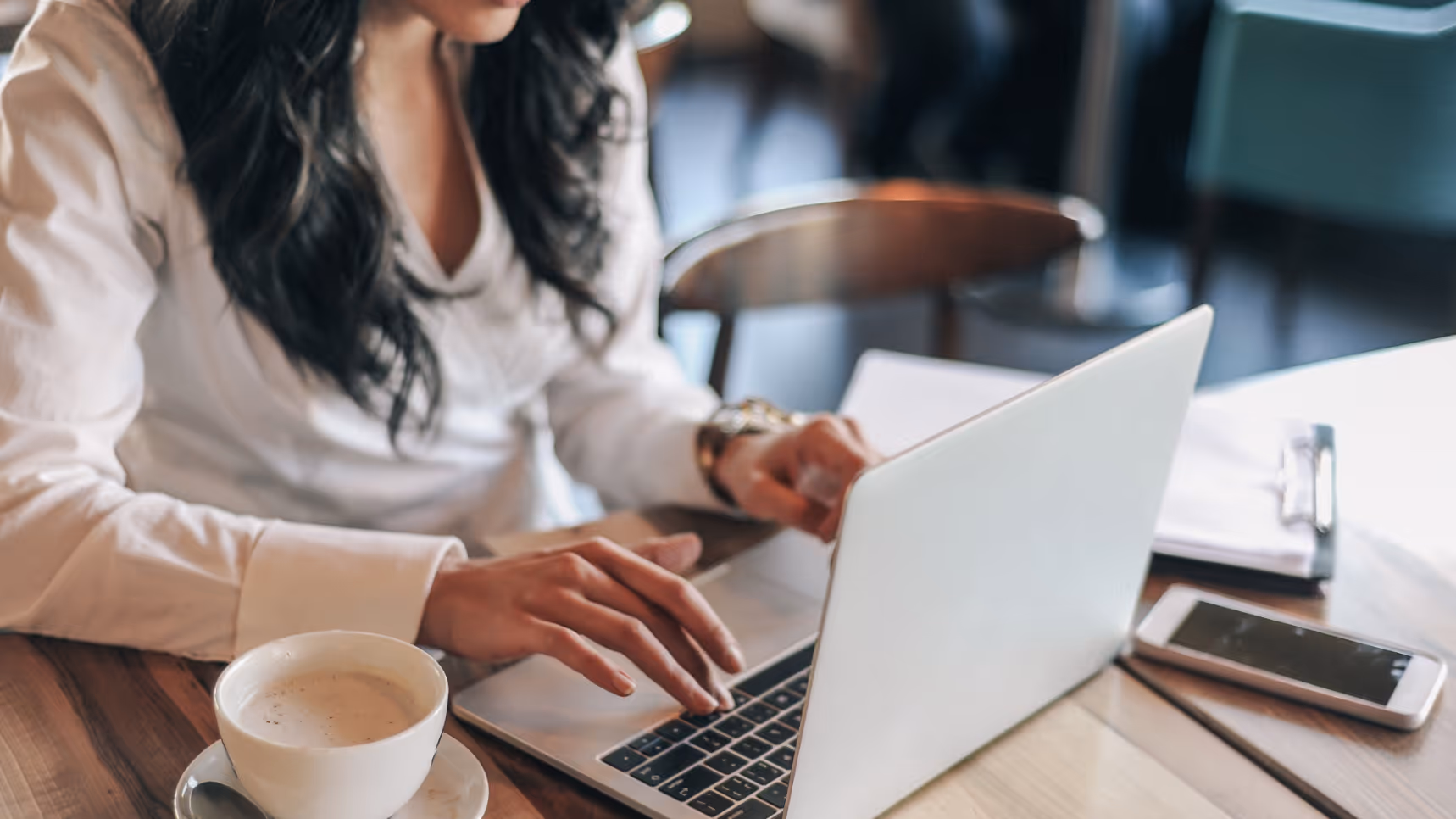 Woman typing on computer with coffee stock image