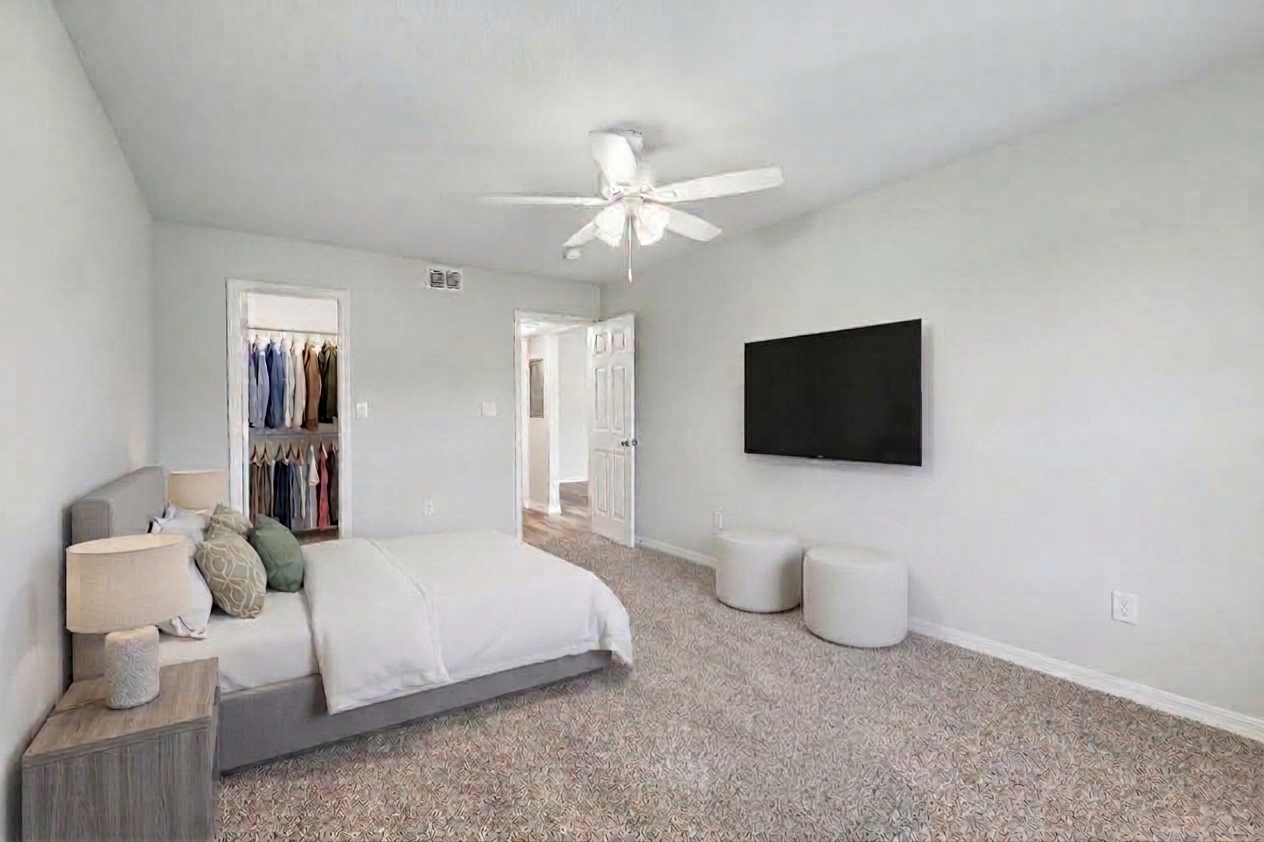 Bedroom with virtually staged furniture including bed, plant, and bedside table with lamp