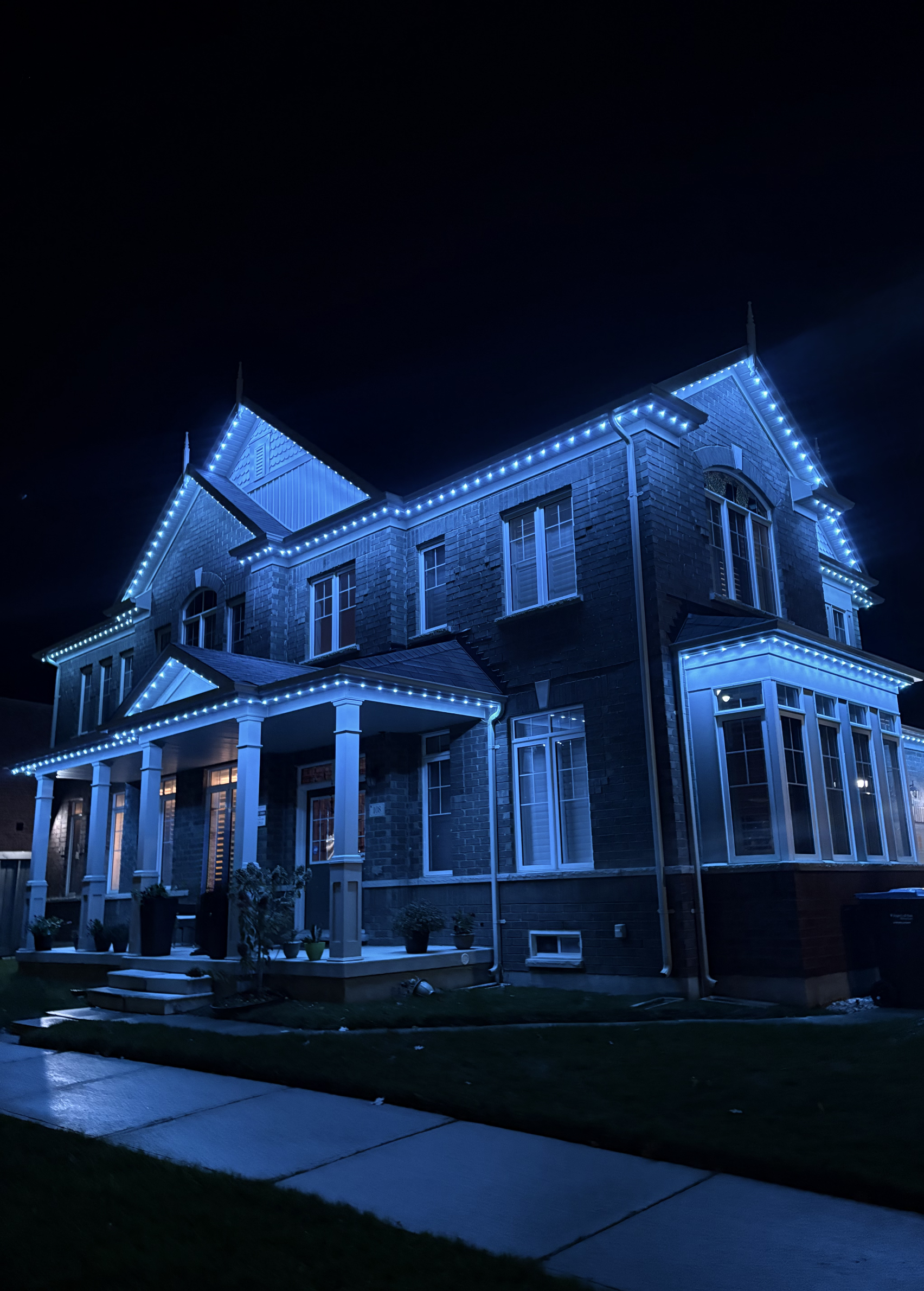 Blue permanent LED lighting installed along soffits and rooflines of large residential home by RoyalShine Lighting in the GTA, showcasing vibrant custom outdoor lighting at night