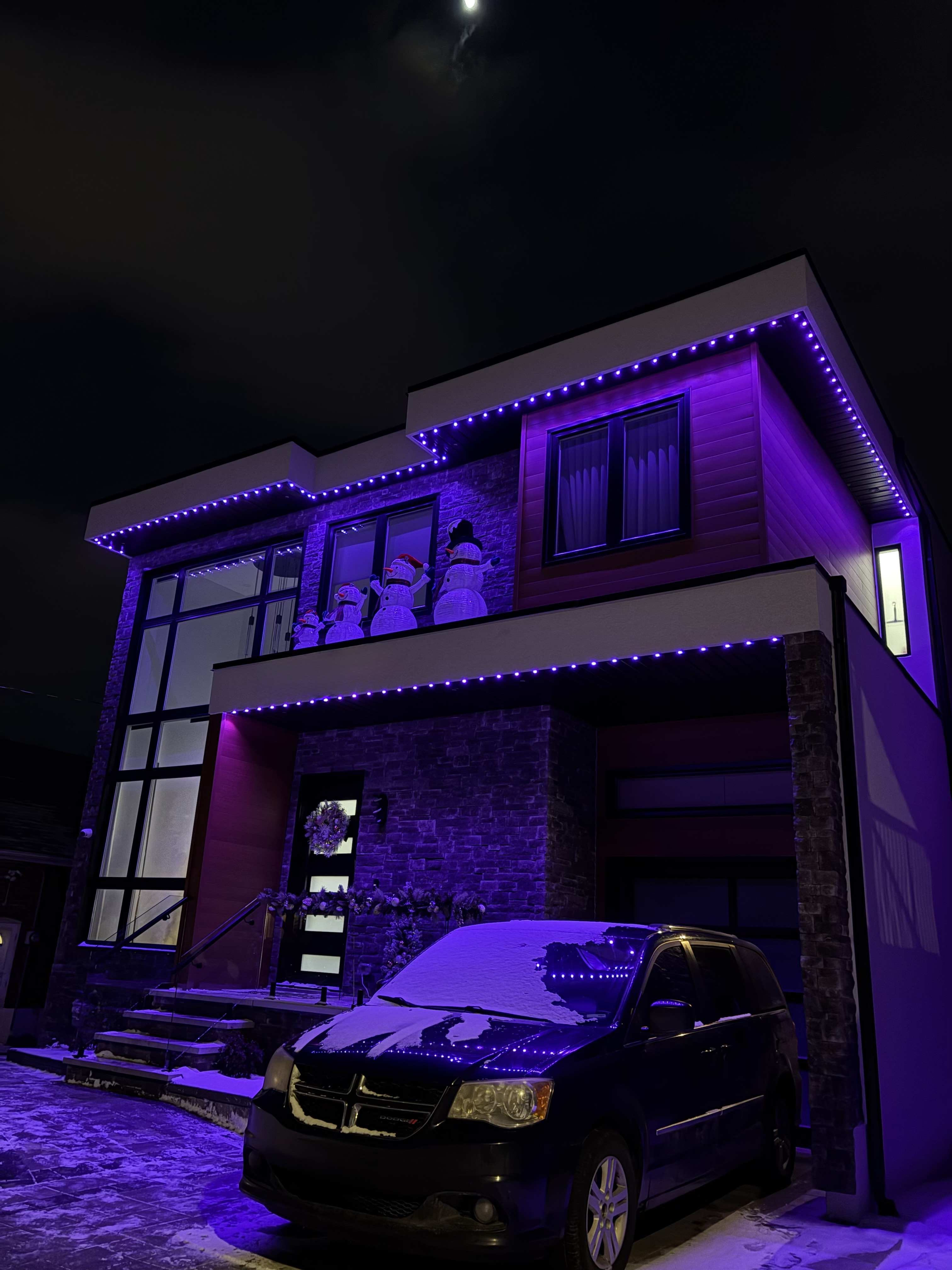 Purple permanent lighting on a modern two-storey home in winter