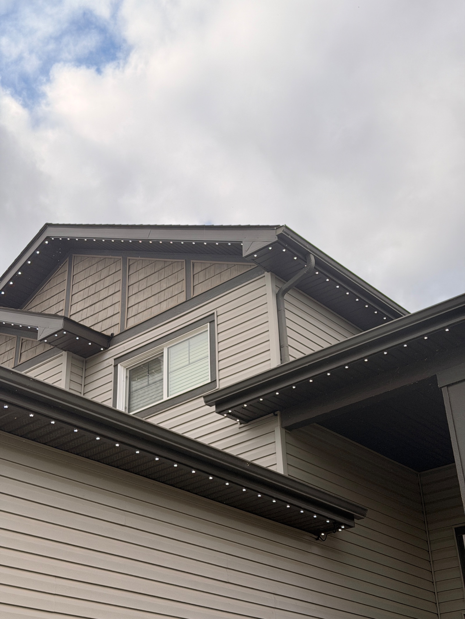 Permanent lighting installed along dark soffits on a multi-level home