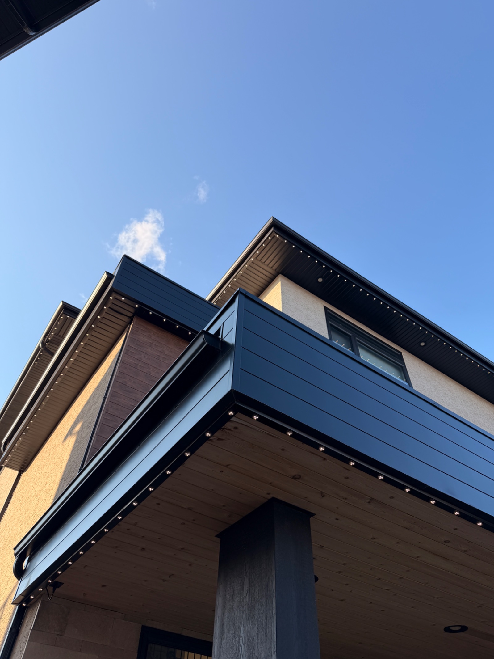 Colour-matched permanent lighting track installed along a modern home soffit